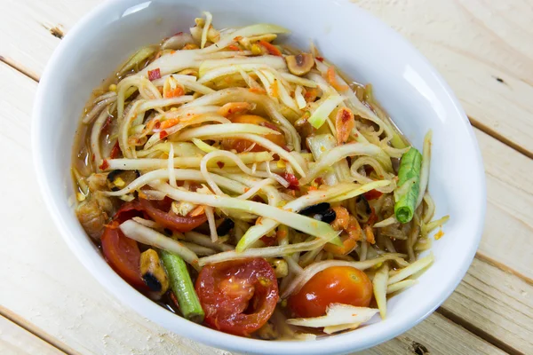 Yeşil papaya Salatası Tay gıda tarzı ahşap arka plan üzerinde.