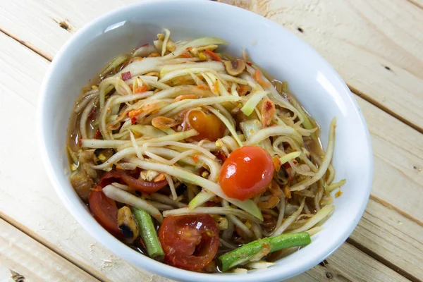 Yeşil papaya Salatası Tay gıda tarzı ahşap arka plan üzerinde.