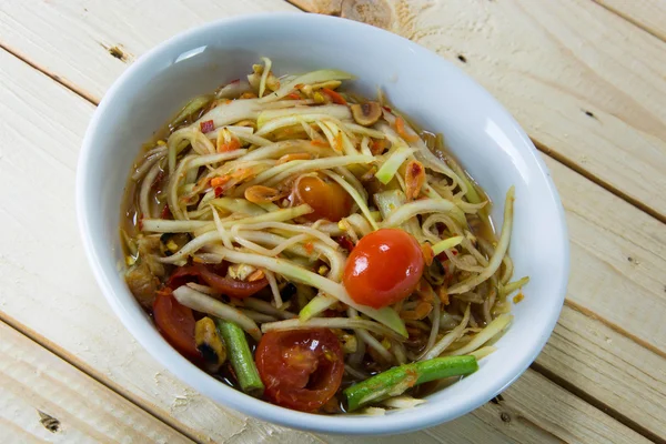 Yeşil papaya Salatası Tay gıda tarzı ahşap arka plan üzerinde.