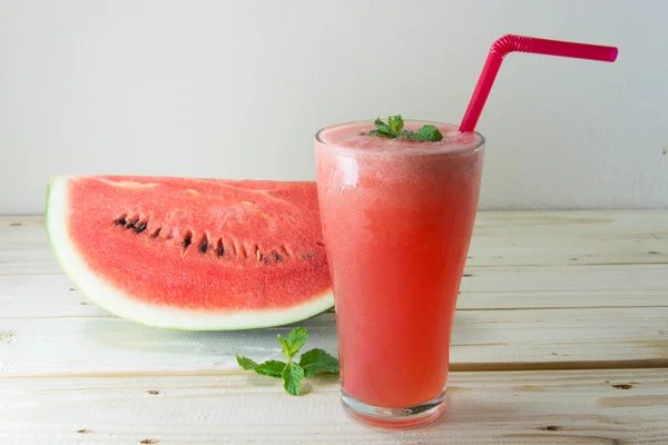 Bicchiere di succo d'anguria fresco con foglie di menta sul tavolo di legno — Foto Stock