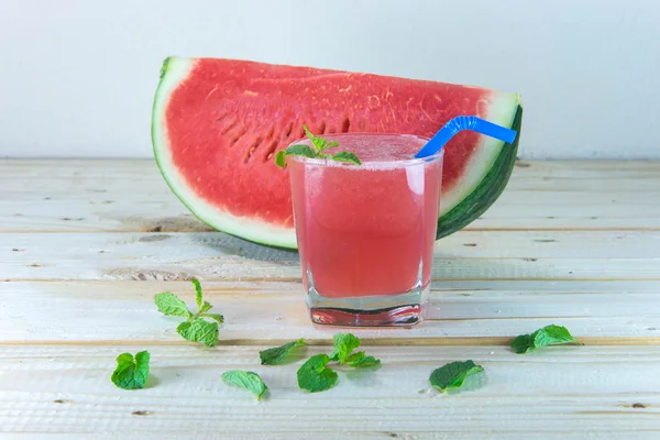 Bicchiere di succo d'anguria fresco con foglie di menta sul tavolo di legno — Foto Stock