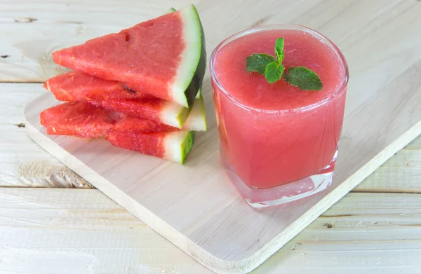 Bardak taze karpuz suyu ile nane yaprakları ve frui dilimlenmiş