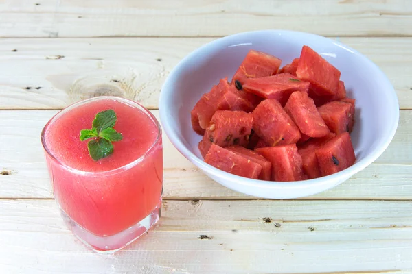 Bicchiere di succo d'anguria fresco con foglie di menta sul tavolo di legno — Foto Stock