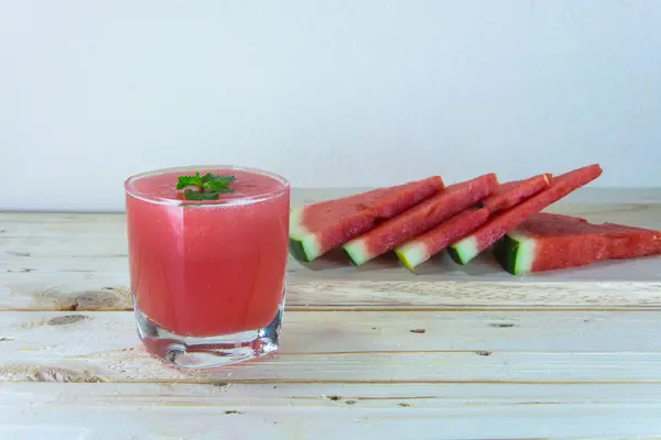 Zumo de sandía con hojas de menta y fruta en rodajas en la madera b —  Fotos de Stock