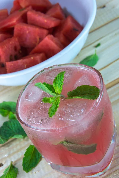 Glass of fresh watermelon juice with mint leaves and ice, on woo — Stock Photo, Image