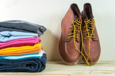 Natürmort ekose gömlek, kot pantolon, ahşap masa üzerinde kahverengi botları ile 