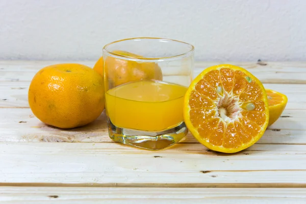 Glass of delicious orange juice and slices of orange on wooden t — Stock Photo, Image