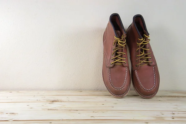 Still life with boots on wooden table background. — Stock Photo, Image