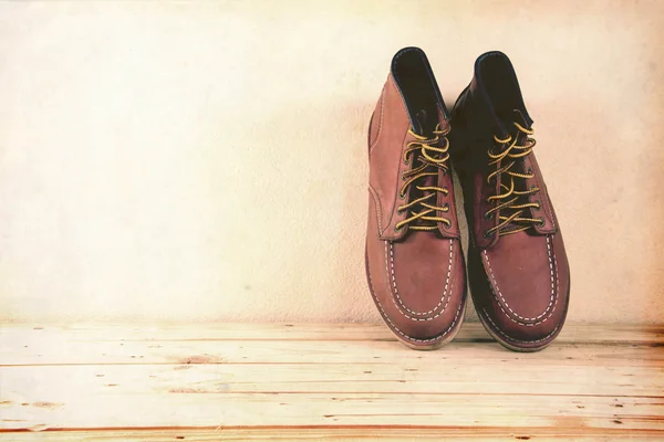 Still life with boots on wooden table background. vintage style. — Stock Photo, Image