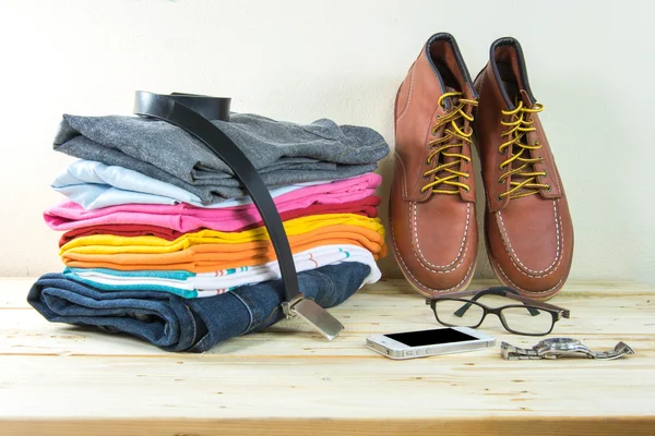 Still life with plaid shirt, jeans, brown boots on wooden table — Stock Photo, Image