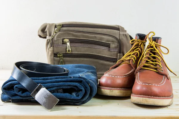 Still life with plaid shirt, jeans, brown boots and bag on woode — Stock Photo, Image