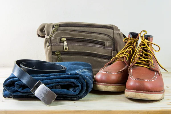 Still life with plaid shirt, jeans, brown boots and bag on woode — Stock Photo, Image