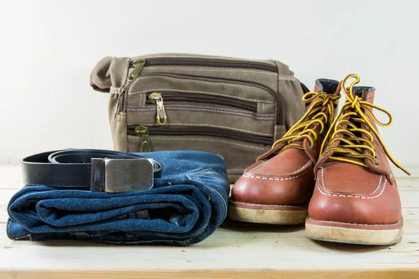 Still life with plaid shirt, jeans, brown boots and bag on woode — Stock Photo, Image