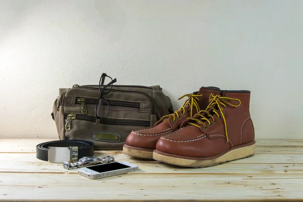 Still life with casual man, boots and bag on wooden table backgr — Stock Photo, Image