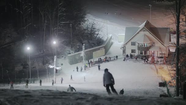 Люди катаються на лижах вночі — стокове відео