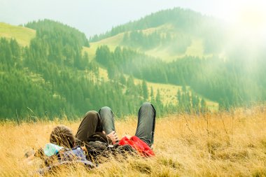 Çift ön planda güzel dağlar tepeler üzerinde yalan