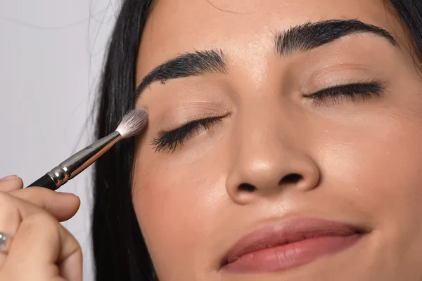 Mujer aplicando sombra de ojos —  Fotos de Stock