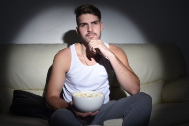 Patlamış mısır yemek ve film izlerken bir genç adam