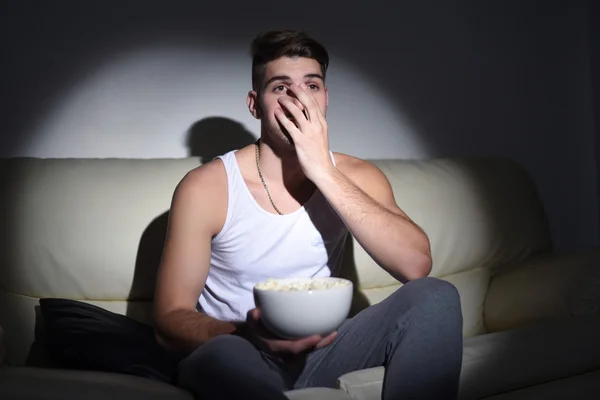 Jeune homme manger du pop-corn et regarder des films — Photo