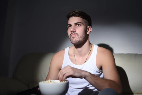 Jeune homme manger du pop-corn et regarder des films — Photo