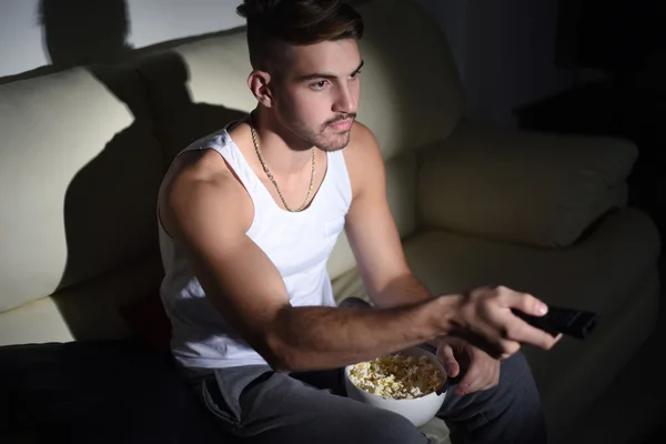 Patlamış mısır yemek ve film izlerken bir genç adam — Stok fotoğraf