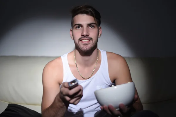 Jeune homme manger du pop-corn et regarder des films — Photo