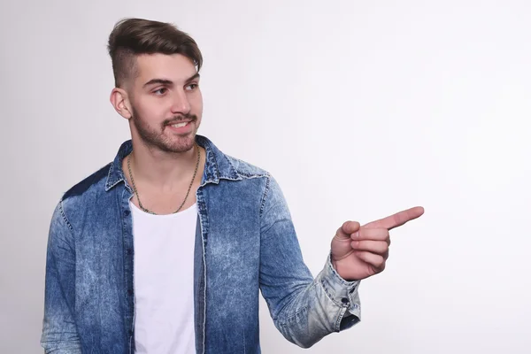 Joven apuntando al fondo blanco . — Foto de Stock