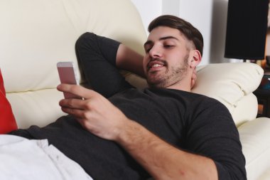 Yakışıklı delikanlı telefonda yazarak  