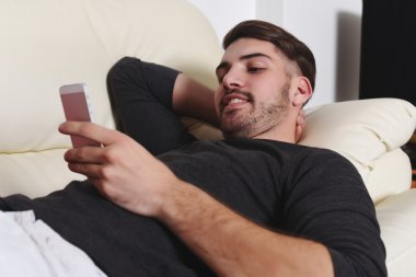 Yakışıklı delikanlı telefonda yazarak  