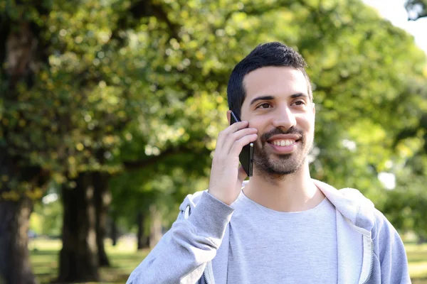 A fiatalember beszél a telefonon. A szabadban. — Stock Fotó