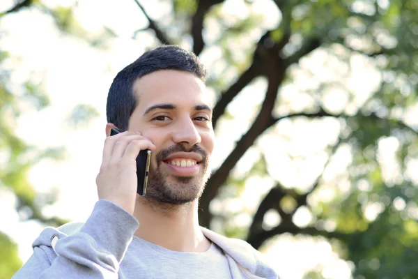 A fiatalember beszél a telefonon. A szabadban. — Stock Fotó