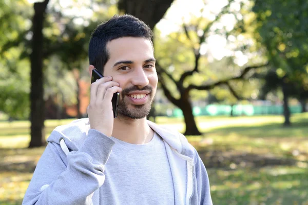 A fiatalember beszél a telefonon. A szabadban. — Stock Fotó