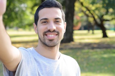 Bir selfie bir parkta alarak genç latin adam. 