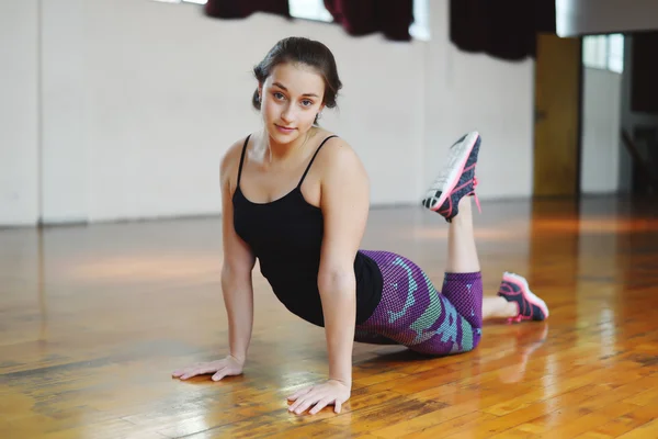 Atleta mujer joven haciendo ejercicio en el gimnasio. En interiores . —  Fotos de Stock