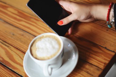 Akıllı telefon kullanan genç bir kadın.