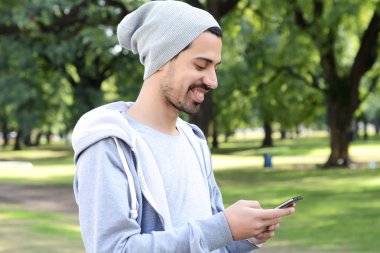 Onun akıllı telefon kullanan Latince adam. Açık havada.