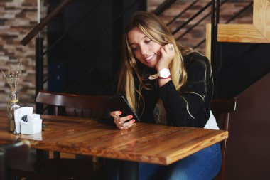 Akıllı telefon kullanan genç bir kadın.