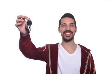 Araba anahtarları tutan genç latin adam portresi.