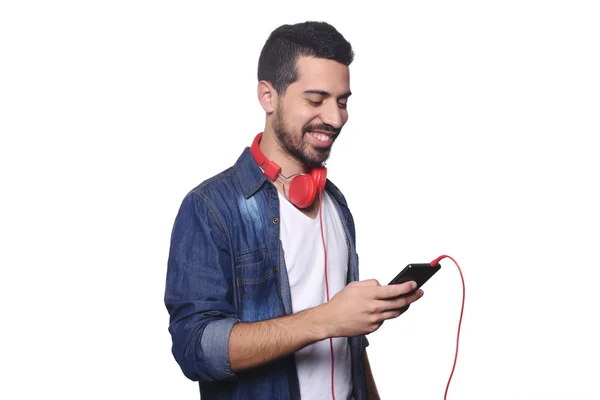 Jeune homme latino avec écouteurs et smartphone . — Photo