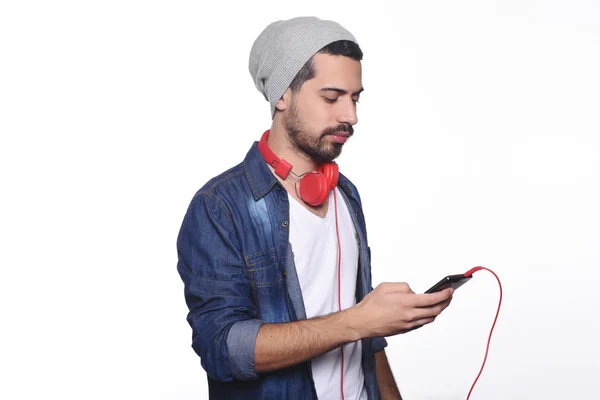 Jeune homme latino avec écouteurs et smartphone . — Photo