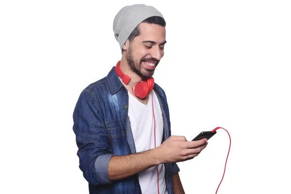 Latin fiatalember fejhallgató és smartphone. — Stock Fotó