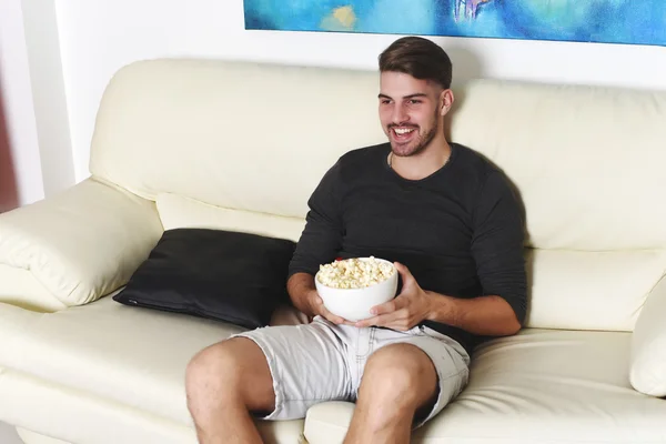 Jeune homme manger du pop-corn et regarder des films — Photo