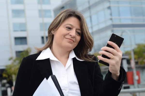 Retrato de una mujer de negocios leyendo un mensaje en su teléfono . —  Fotos de Stock