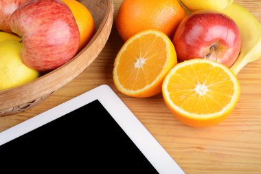Meyve ve ahşap masa üstünde a Tablet Pc.