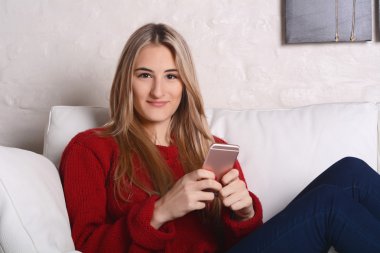 Genç kadın smartphone sahip iletileri gönderme portresi.