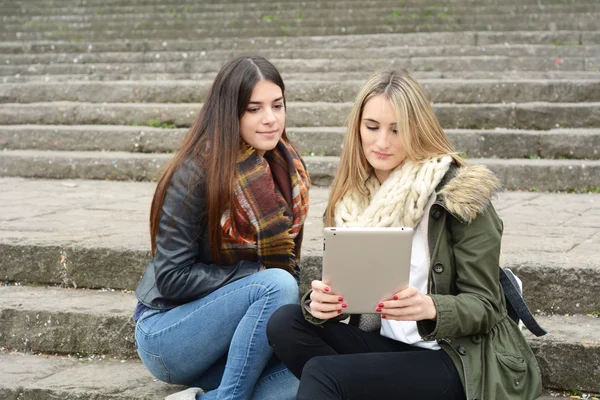 Dos novias jóvenes en un viaje juntas y usando la tableta . —  Fotos de Stock