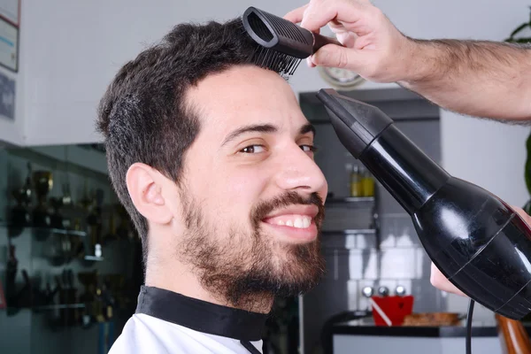 Erkek Kuaför ve saç kurutma makinesi ile onun saç kurutma. — Stok fotoğraf