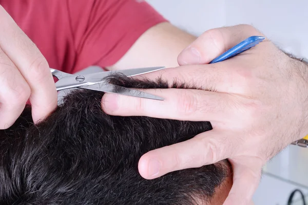 Genç adam makasıyla saçını kestiriyor.. — Stok fotoğraf