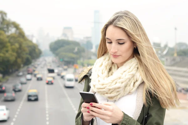 Ung kvinna skickar meddelanden med sin smartphone. — Stockfoto