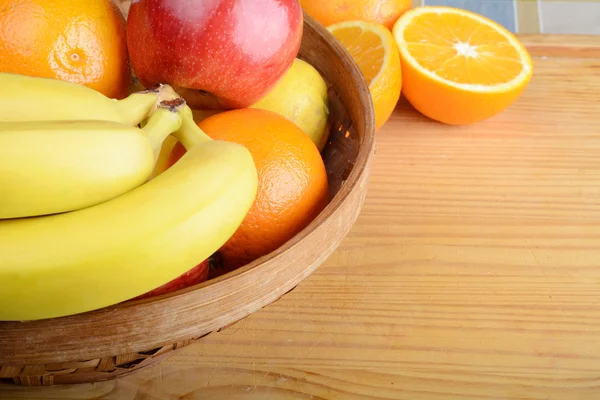 Cesta de frutas sobre mesa de madera . — Foto de Stock